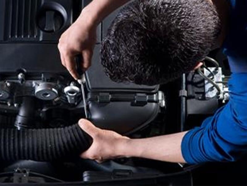 image of a man working on a car