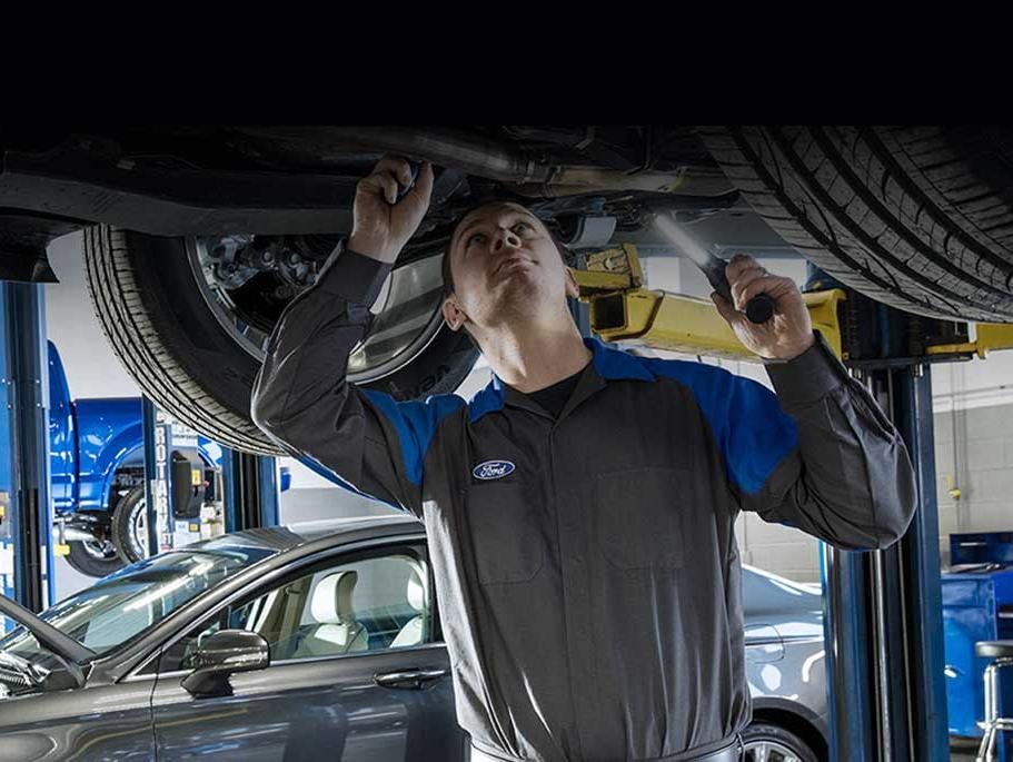 image of a man working under a car
